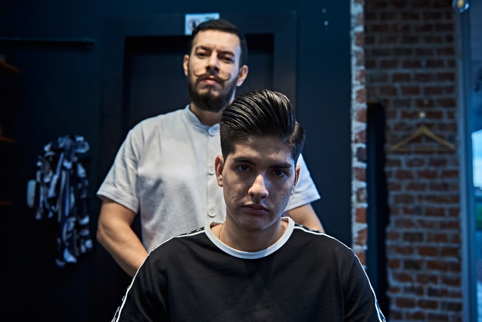 Barbero de U Delivery Barber junto a un cliente con corte pompadour