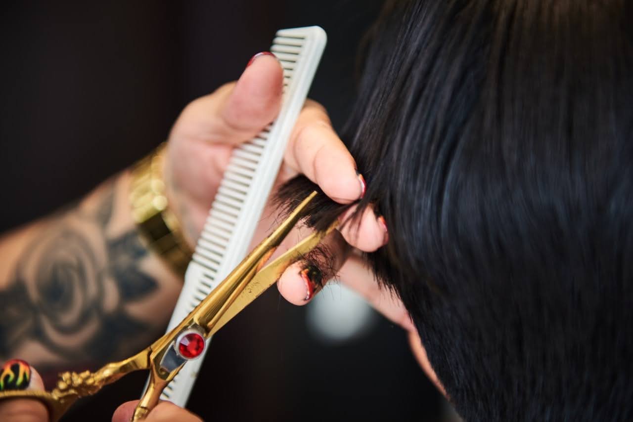 Corte de precisión con tijera y peine sobre cabello oscuro